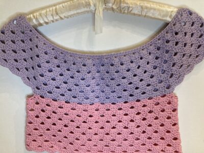 pink and purple crochet crop top on hanger